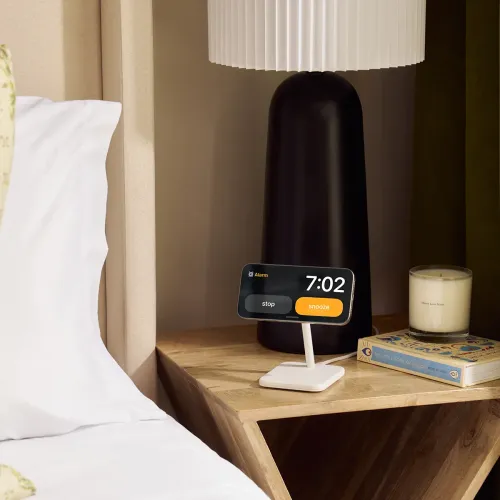 Twelve South HiRise 2 Deluxe wireless charging stand holding a phone in landscape on a bedside table