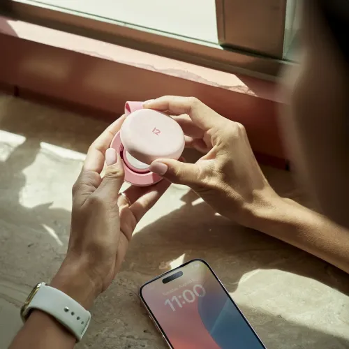 Twelve South butterFly SE salokāms rozā bezvadu lādētājs 2 vienā, atvērts blakus iPhone