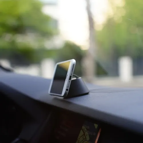 Soporte para teléfono iRing Dock en el salpicadero del coche, que mantiene el smartphone en posición vertical para la navegación manos libres.